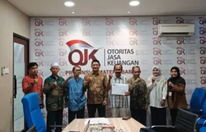 Kepala OJK Provinsi Sumatera Barat, Roni Nazra, menyerahkan langsung surat keputusan tersebut kepada pengurus kedua entitas perbankan di Kantor OJK Sumatera Barat, Kamis (25/6/2026).