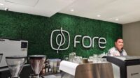 Logo Fore Coffee pada gerai modern dengan suasana ramai pengunjung