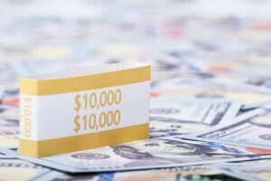 Close-up of a stack of $10,000 US dollar bills with a currency strap on a background of paper money.