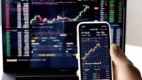 Layar monitor menampilkan grafik pergerakan saham dan data bursa efek di kantor Bursa Efek Indonesia