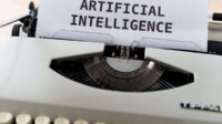A close-up of a typewriter showcasing 'ARTIFICIAL INTELLIGENCE' on paper.