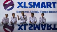 8b307c2b17ce444d098c9eb475b9d7c3.jpg Logo XLSmart dengan latar belakang menara telekomunikasi dan perangkat jaringan 5G modern