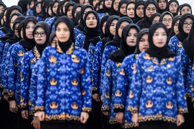 Ilustrasi guru sedang mengerjakan ujian di depan layar komputer di ruang kelas